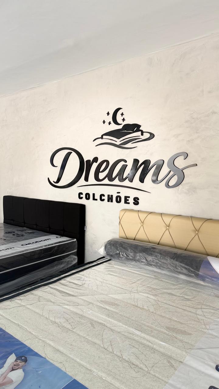 Logomarca Dreams Colchões aplicada na parede do showroom